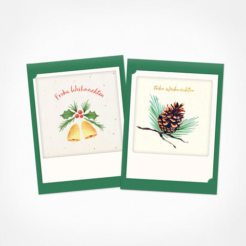 Das Pickmotion "Besinnliche Weihnachten" 2er Kleine Klappkarten-Set enthält zwei grün umrandete Weihnachtskarten mit festlichen Glocken-, Stechpalmen- und Tannenzapfen-Illustrationen - beide mit dem Gruß "Frohe Weihnachten".