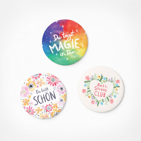 Set aus 3 bunten, runden Pickmotion Aufmunterungs-Magneten (Größe M) mit deutschen Sprüchen, floralen Motiven und dezenten Sternzeichen auf weißem Hintergrund.