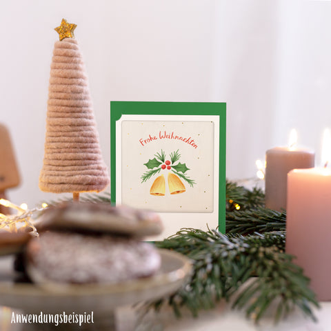 Das Pickmotion "Besinnliche Weihnachten" 2er Kleine Klappkarten-Set zeigt festliche Illustrationen von Glocken, Plätzchen, Kerzen und einem Baumschmuck auf einem fröhlichen Tisch.