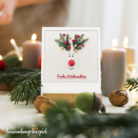 Das Pickmotion Heimelige Grüße 5er Postkarten-Set enthält festliche Karten mit Rentiergesichtern aus Tannenzweigen und Goldeffekten sowie "Frohe Weihnachten"-Text-ideal für Instagrammer*innen oder als Inspiration für Weihnachtsgrüße.