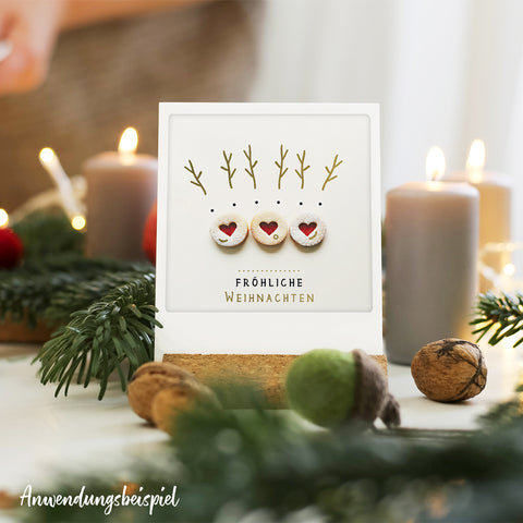 Das Pickmotion Zauberhafte Zeit 8er Postkarten-Set enthält festliche Karten mit hölzernen Rentiergesichtern, Kerzen und Grünzeug - ideal für eine charmante Weihnachtsdekoration.