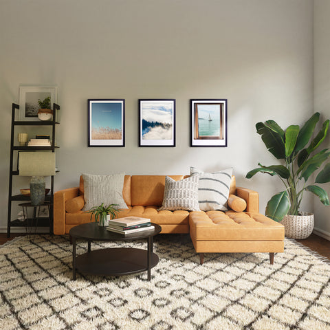 Modernes Wohnzimmer mit hellbraunem Sofa, gemustertem Teppich, Pflanze, Regal, und "breathe" Art Poster von Pickmotion in einem maßgefertigten Bilderrahmen für stilvollen Charakter an der Wand.