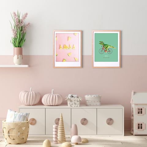 Ein pastellrosa Kinderzimmer mit stilvollem Flair, mit dem Kunstposter "summer vibes" von Pickmotion in einem individuellen Rahmen, weicher Dekoration, Spielzeug und einem Puppenhaus auf einem weißen Schrank.