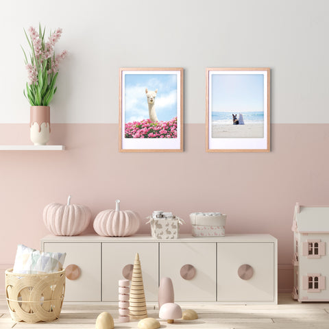 Ein pastellfarbenes Kinderzimmer mit stilvollem Charakter, in dem die "beach buds"-Drucke von Pickmotion in maßgefertigten Bilderrahmen zusammen mit Kuscheltieren und dekorativen Körben auf einem weißen Regal stehen.