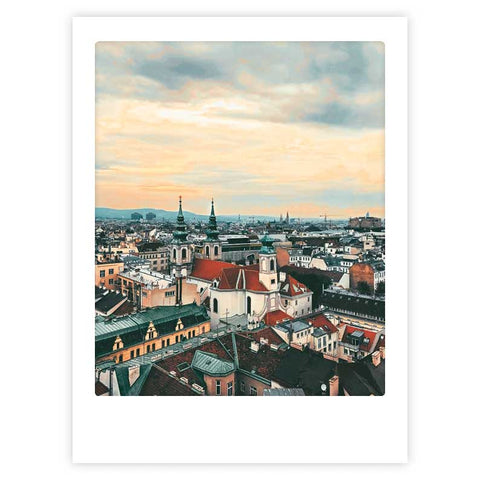 Das Kunstposter "blick über die stadt" von Pickmotion zeigt farbenfrohe Dächer und Kirchtürme im Sonnenuntergang und verleiht jedem Raum stilvollen Charakter - perfekt für Ihre Lieblingsbilderrahmen.