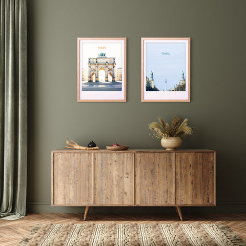Ein hölzernes Sideboard mit Dekoration, eine grüne Wand, das "Walk into the light"-Kunstposter von Pickmotion in einem maßgefertigten Rahmen, gerahmte Stadtdrucke und ein langer linker Vorhang - ideal für den Raum eines jeden internationalen Instagrammer.