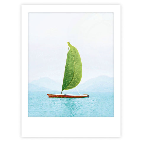 Sail away with me" von Pickmotion zeigt ein kleines Boot mit einem großen grünen Blättersegel, das auf blauem Wasser vor Bergen treibt - ein Kunstposter mit stilvollem Charakter, ideal für maßgefertigte Bilderrahmen.