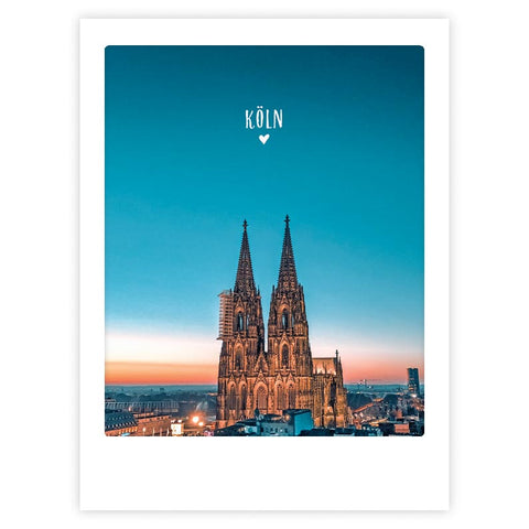 Blue hour in cologne" von Pickmotion fängt den stilvollen Charakter der Stadt bei Sonnenuntergang ein, mit dem Kölner Dom unter strahlend blauem Himmel und dem Schriftzug "Köln" darüber - eingerahmt wie eine Postkarte, ist dieses Art Poster eine perfekte Hommage an die Stadt.