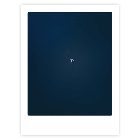 Eine einsame Figur schwimmt in tiefblauem Wasser und bildet Wellen - 'the big blue' von Pickmotion ist ein minimalistisches Kunstposter, das jedem Raum stilvollen Charakter verleiht.