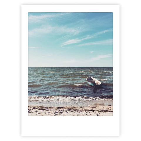 Boot auf dem Wasser" von Pickmotion: Ein kleines Ruderboot treibt in Ufernähe an einem friedlichen Strand unter einem blauen Himmel - ein Kunstposter mit stilvollem Charakter für jeden Raum.