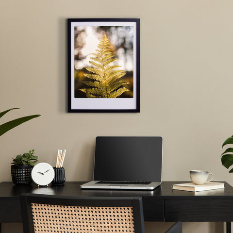 Ein moderner Arbeitsbereich mit Laptop, Pflanzen und dem "sunbeams" Art Poster von Pickmotion in einem individuellen Rahmen verleiht der beigen Wand einen stilvollen Charakter.
