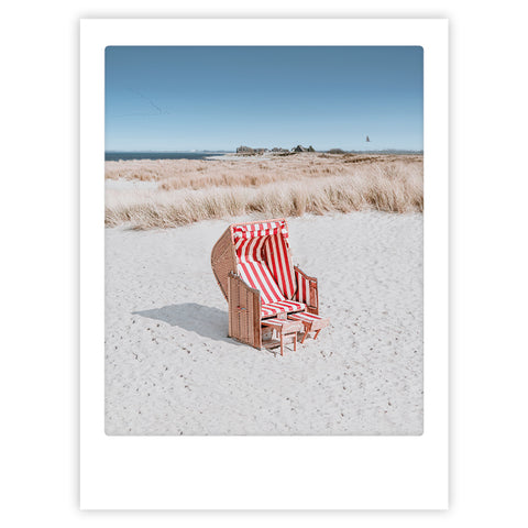 Das Kunstposter "a place just for us" von Pickmotion zeigt einen rot-weiß gestreiften Strandkorb auf sandigen Dünen mit hohem Gras unter einem klaren blauen Himmel - perfekt, um Ihrem Raum eine entspannte Küstenatmosphäre zu verleihen.