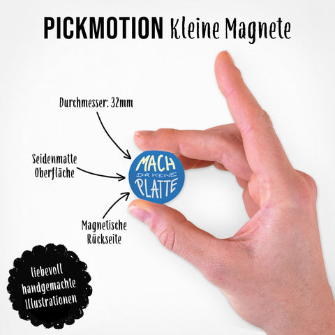 Eine Hand hält einen kleinen blauen Magneten von Pickmotion aus dem Set "Coole Sprüche | Magnet Set | 5 Magnete S", umgeben von süßen Illustrationen, Labels und Pfeilen an einer magnetischen Wand.