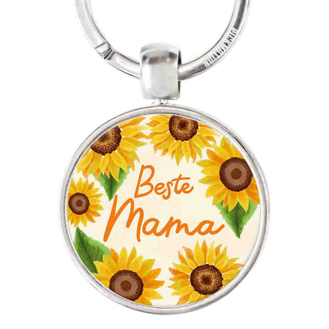 Der runde Schlüsselanhänger "Beste Mama" von Pickmotion besticht durch Sonnenblumen, den orangefarbenen Schriftzug "Beste Mama" in der Mitte, einen stabilen Edelstahl-Schlüsselring und einen detailreichen Reliefdruck.