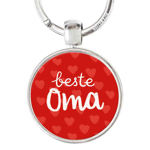 Der "beste Oma"-Schlüsselanhänger von Pickmotion hat einen roten Hintergrund, ein kleines Herzmuster und eine weiße Schrift - ein charmantes Geschenk und praktisches Accessoire für jede Großmutter.