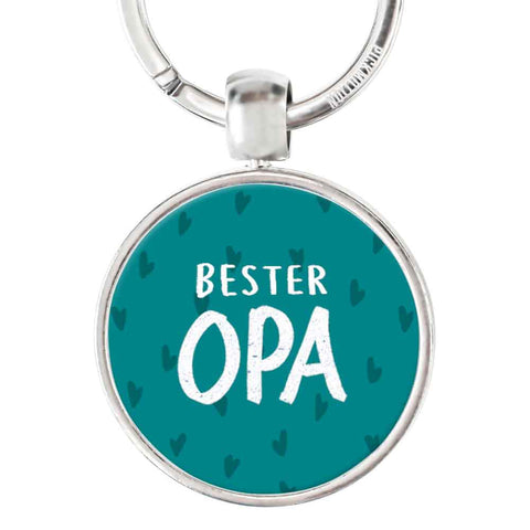 Runder Schlüsselanhänger von Pickmotion mit tealem Hintergrund, kleinen Herzmustern und weißem "bester Opa"-Text, gefertigt aus robustem Edelstahl und veredelt mit hochwertigem Reliefdruck.