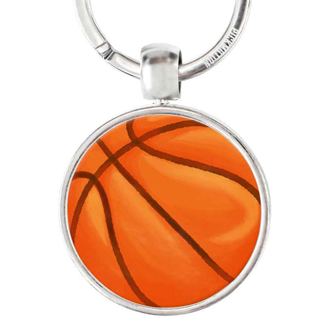 Ein runder Pickmotion Schlüsselanhänger aus Edelstahl zeigt im silbernen Rahmen einen reliefgeprägten, orangefarbenen Basketball.