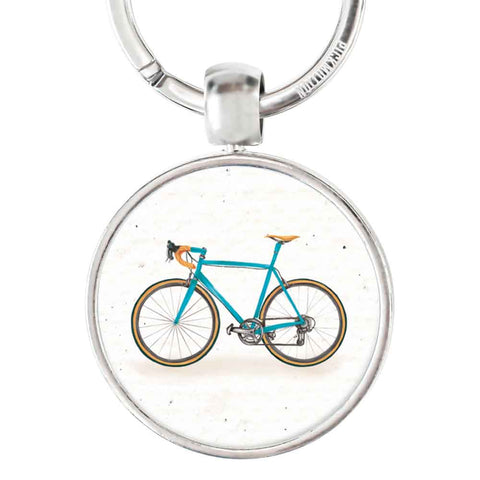 Ein Schlüsselanhänger von Pickmotion mit rundem Edelstahl-Anhänger, verziert mit einer Relief-Illustration des blauen Fixie-Bikes.