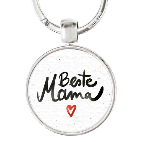Runder Schlüsselanhänger von Pickmotion mit "beste mama" in schwarzem Reliefdruck und kleinem roten Herz auf weiß - das perfekte Accessoire für besondere Mamas.