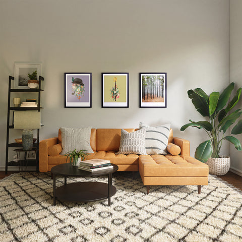 Ein gemütliches Wohnzimmer mit einem hellbraunen Sektionssofa, einem gemusterten Teppich, Pflanzen für einen stilvollen Charakter und Pickmotion's Vintage Flower Vibes Wandkunst in maßgefertigten Bilderrahmen.
