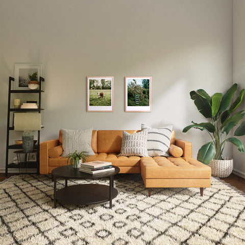 Helles Wohnzimmer mit hellbrauner Couchgarnitur, gemustertem Teppich, Pflanzen und dem Kunstposter "All cows are beautiful" von Pickmotion an der Wand.
