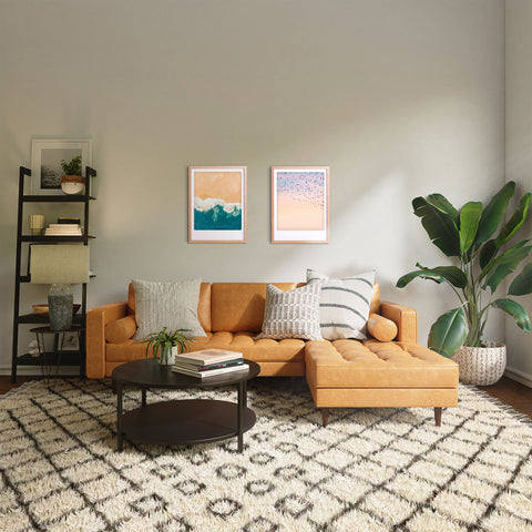 Modernes Wohnzimmer mit hellbraunem Sektionssofa, gemustertem Teppich, Pflanzen und "birds of feather" Kunstposter von Pickmotion in maßgefertigten Bilderrahmen an der Wand für stilvollen Charakter.