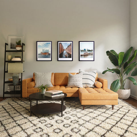 Modernes Wohnzimmer mit hellbraunem Sektionssofa, gemustertem Teppich, Pflanzen, maßgefertige Bilderrahmen, Pickmotion Art Poster "great view", und einem runden Couchtisch für stilvollen Charakter.