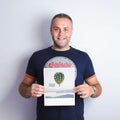 Ein lächelnder Mann hält ein Plakat mit einem Heißluftballon und dem Text Alles ist möglich.