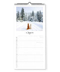 Zwei Hunde sitzen auf einem verschneiten Weg in einem Winterwald, abgebildet auf dem Januarblatt des Bunter Hund - Familienplaner (Format 20x42) von Pickmotion - der perfekte Hundekalender für die ganze Familie.