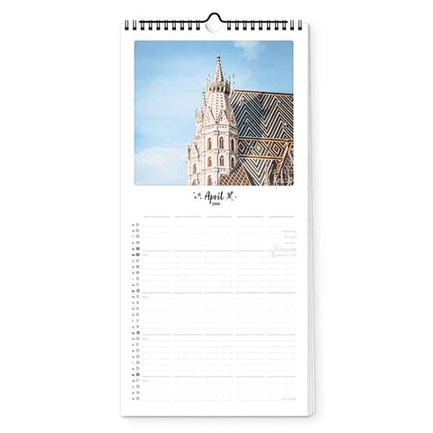Der Pickmotion Wien - Planer (Format 15x40) ist ein Wandkalender für den Monat April, der eine beeindruckende Kathedrale mit einem gemusterten Dach zeigt - ideal für Architekturfans, die einen stilvollen Monatsplaner suchen.