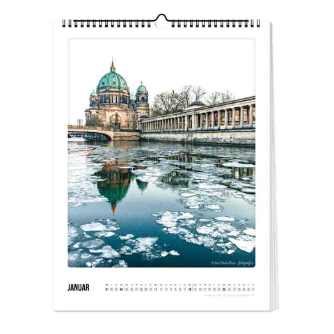 Der Pickmotion Berlin - Kalender (Format 30x40) zeigt auf der Seite "Januar" den Berliner Dom an einem Fluss mit schwimmendem Eis, präsentiert in minimalistischem Design.