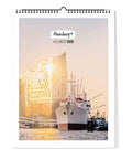 Das Cover von Pickmotion Hamburg - Kalender (30x40) 2026 zeigt ein Schiff und die Elbphilharmonie bei Sonnenuntergang und spiegelt das ikonische nordische Design der Stadt wider.