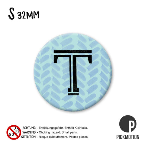 Der "spring t/2" von Pickmotion ist ein 32mm großer, runder Pin mit einem auffälligen schwarzen T auf blau gemustertem Hintergrund - ideal als runde Magnete für Ihre Sammlung oder als stylische Kühlschrankmagnete, die jeden Kühlschrank verschönern.