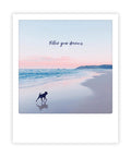Ein Hund läuft bei Sonnenuntergang am Strand, aufgenommen im Sofortbild-Stil, mit "follow your dreams" darüber - ideal für Postkarten oder Instagram-Liebhaber*innen, die Inspiration suchen. Von Pickmotion.